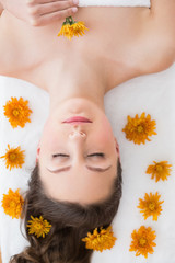 Brunette lying on massage table in beauty salon