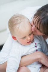 Fototapeta na wymiar Mother kissing a baby