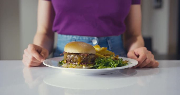 Woman eating burger and fries