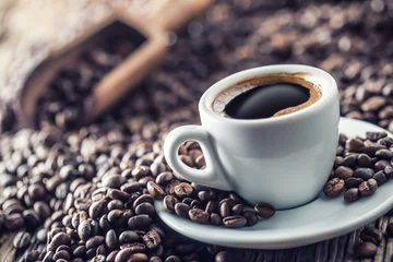 Foto op Plexiglas Kopje zwarte koffie met bonen op houten tafel © weyo