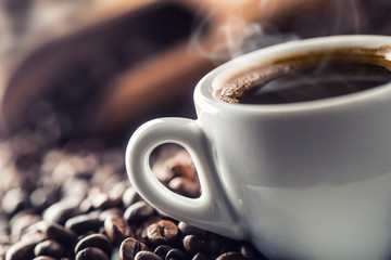 Tasse schwarzen Kaffee mit Bohnen auf Holztisch