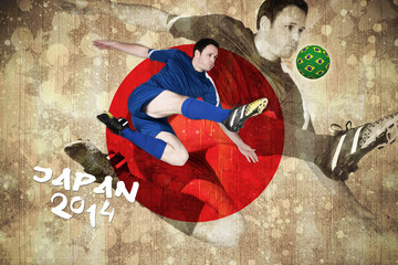 Football player in blue kicking against japan flag in grunge effect