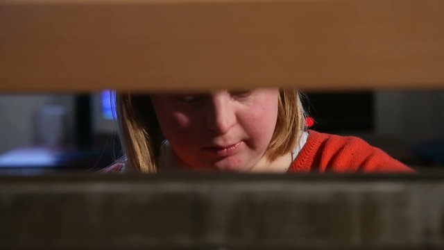 Young woman with down syndrome weaving loom 