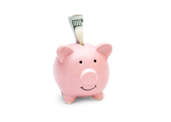 Folded money in piggy bank on white background.