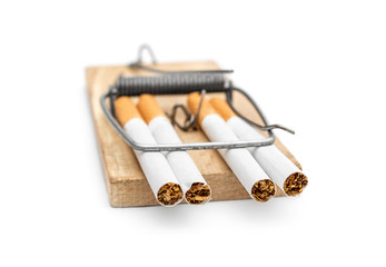 Closed mousetrap with cigarettes on white.