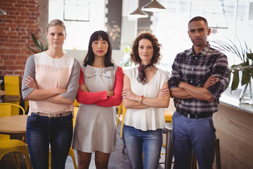 Confident young friends standing with arms crossed