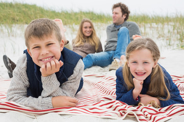 Fototapeta premium Happy family of four at a beach picnic