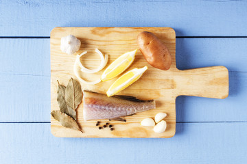 Fototapeta na wymiar Ingredients for cooking healthy food on cutting board. Fresh organic vegetables and sea fish. Natural products closeup. Top view with copy space