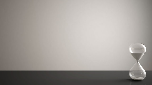 Gray table, desk or shelf with crystal modern hourglass measuring the passing time in a countdown to a deadline, white copy space background