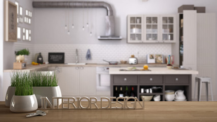Wooden table, desk or shelf with potted grass plant, house keys and 3D letters making the words interior design, over blurred scandinavian kitchen, project concept copy space background