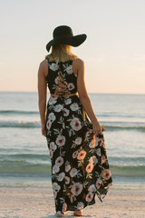 Attractive Young Female Model Posing in Sun Dress and Brimmed Hat at the Beach 