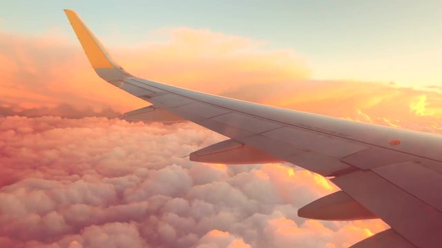 Airplane flight. Wing of an airplane flying above the clouds. View from the window of the plane. Aircraft. Traveling. 4K UHD video footage. 3840X2160