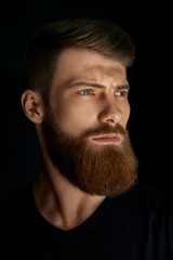 Closeup of a man with beard and mustache over black background. Perfect beard
