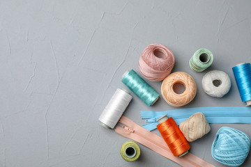 Color sewing threads on gray background, top view