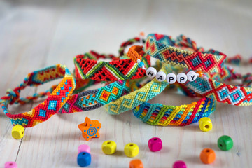 handmade friendship bracelets with colorful threads on light background