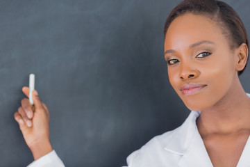 Teacher looking at camera while holding a chalk