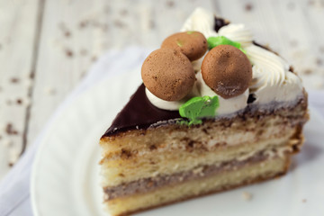 dark chocolate vegan cake with cream and caramel on wooden background