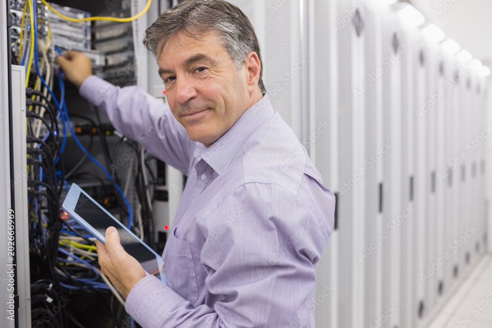 Poster technician using tablet pc to check the servers