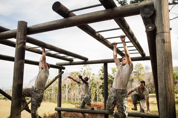 Soldiers climbing monkey bars