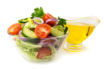 Vegetable salad in glass plate and sunflower oil on a white background.
