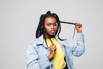 Portrait of woman with hair braided in thin plaits or dreadlocks in african style isolated on gray background