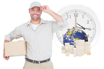 Portrait of happy delivery man with cardboard box wearing cap against logistics graphic