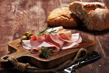 Sliced ham on wooden background. Fresh prosciutto. Pork ham sliced