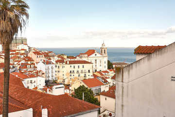 Fototapeta premium Old Lisbon Portugal steet. cityscape with roofs. Tagus river. miraduro viewpoint