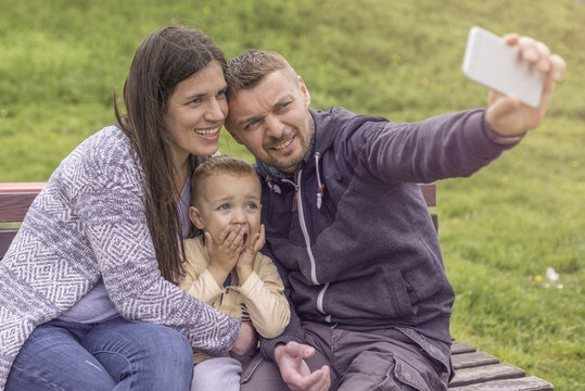Parents having fun with their child in park playground