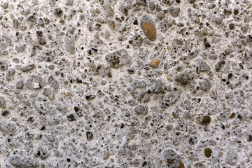 background - grayish-cream rough concrete wall with large filler pebbles