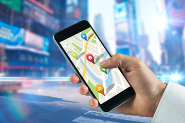 Man using map app on phone against blurred new york street