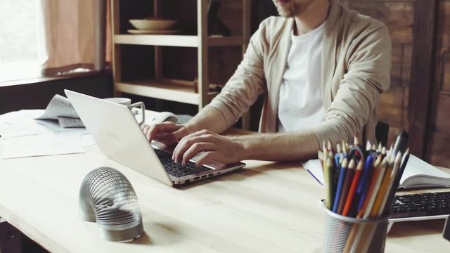 Side view image of young freelancer working at home. Freelance work concept.