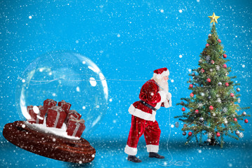 Santa pulling snow globe of presents against blue background with vignette