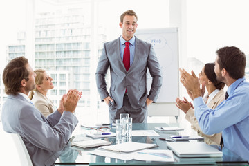 Business people clapping hands in board room meeting