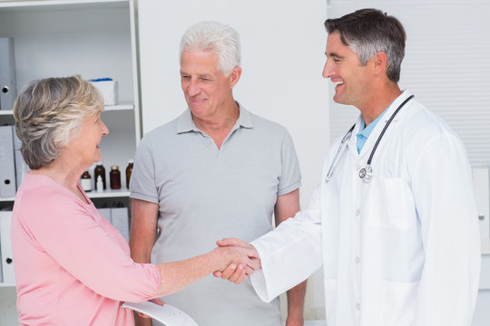 Senior couple smiling while visiting doctor