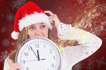 Festive blonde showing a clock against blurred christmas background