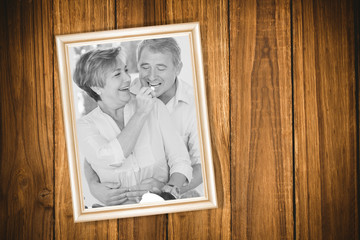 Wooden background against old man tasting vegetable held by wife