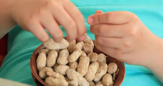 Portrait of a young preteen boy lying on sofa watching television and eating healthy snack