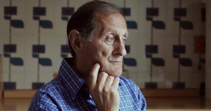 Pensive sad lonely old man at home thinking 