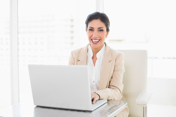 Happy businesswoman working on a laptop