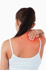 Back view of female with pain in her neck against a white background