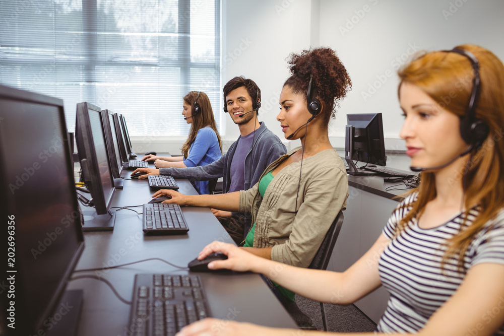 Poster Happy student in computer class smiling at camera