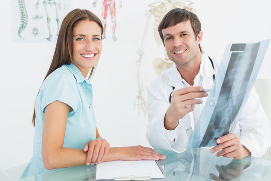 Male doctor explaining spine xray to female patient