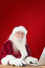 Santa surfs on the internet against red background