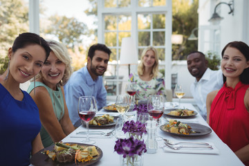 Happy friends having lunch together in restaurant