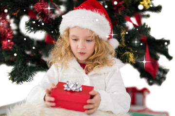 Festive little girl holding a gift against snow