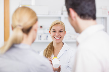 Blonde pharmacist holding a drug box