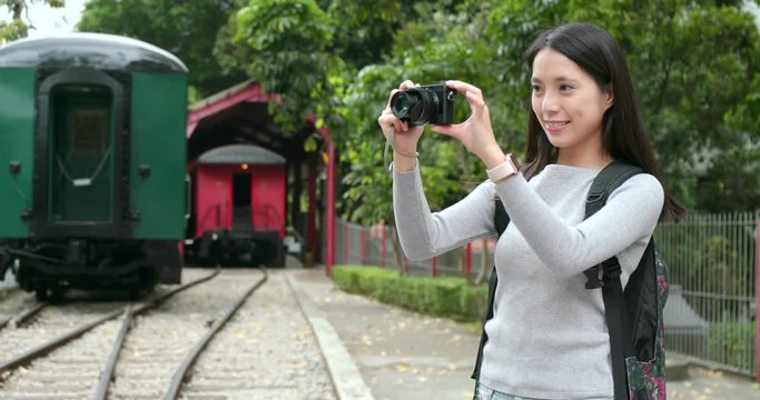 Travel woman taking photo on train station