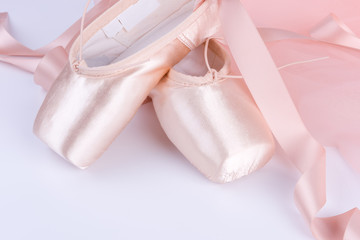 Closeup of ballet shoes with pink ballet costume