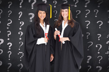 Full length shot of two women graduating against blackboard
